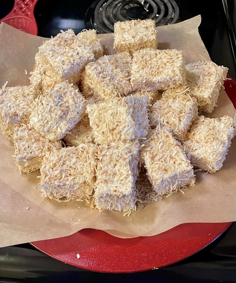 Coconut-covered marshmallow squares on a red plate